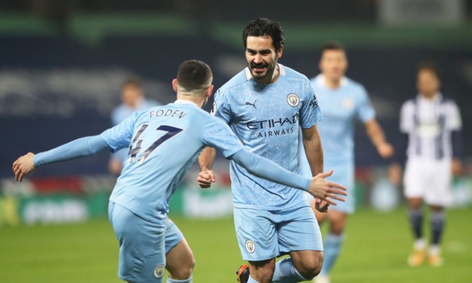 Manchester City's Ilkay Gundogan celebrates scoring their first goal with Phil Foden in a Premier League match against West Bromwich Albion at the Hawthorns in West Bromwich on Tuesday.