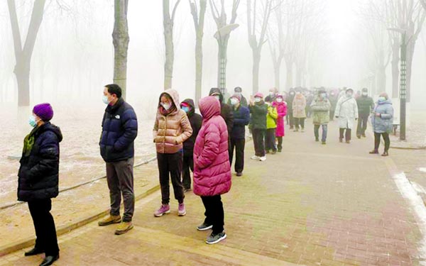People line up for nucleic acid testing at a makeshift testing site in a park following the coronavirus outbreak, on a polluted day in Daxing district of Beijing, China.