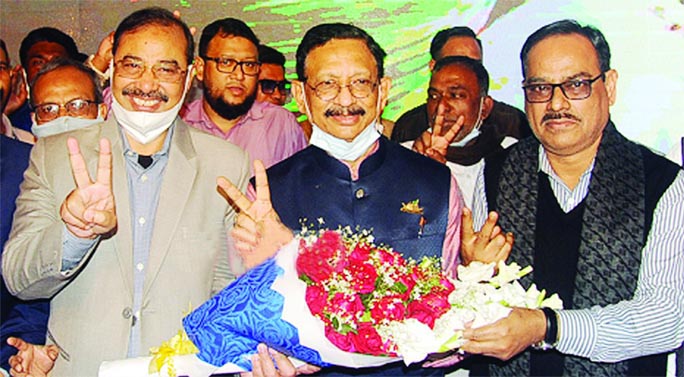 Former Mayor AJM Nasiruddin along with other AL leaders greet newly elected Mayor Rezaul Karim Chowdhury at latter's residence by presenting bouquet yesterday.