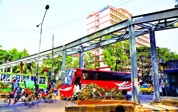 Vehicles plying under construction foot over-bridge in front of Matsya Bhaban in the city on Thursday. The authority is building the foot over-bridge as the area is accident prone.