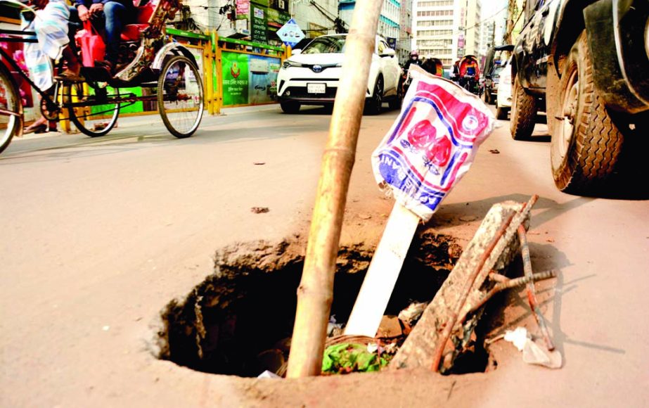 Bamboo and wooden sticks are placed in an open manhole on a road at Segun Bagicha in the capital, posing serious threat to pedestrians and motorists. This photo was taken on Saturday