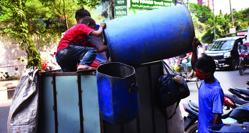 Little boys dump garbage in a van at Motijheel area in the capital in this file photo.
