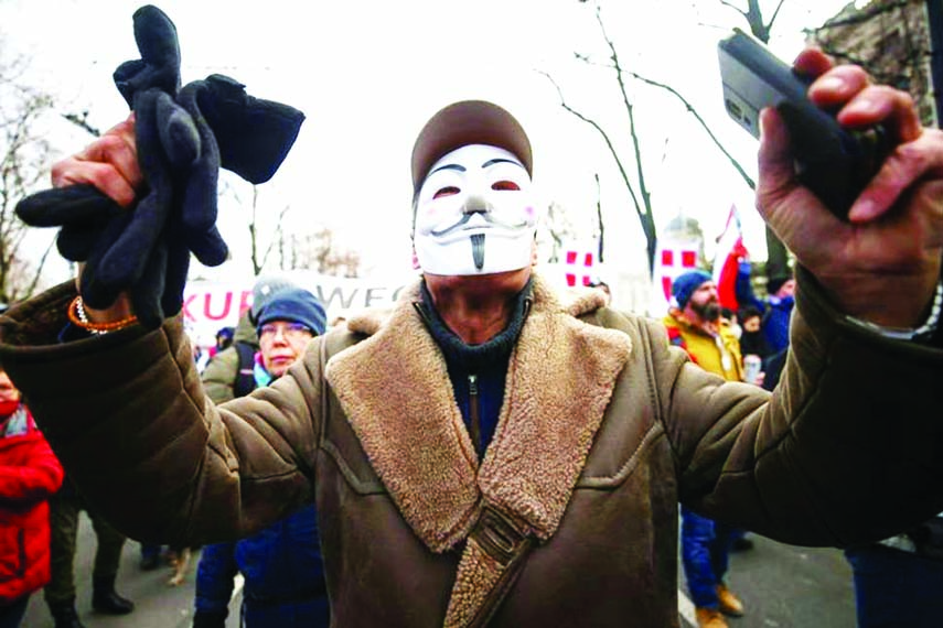 A man wearing a mask gestures during a demonstration against the coronavirus measures and their economic consequences in Vienna, Austria.