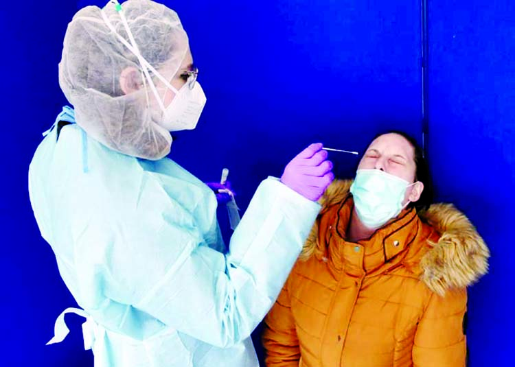 A health care worker takes a swab sample from a person to test for the coronavirus, at a drive-in testing site of the CHR Centre Hospitalier Regional de la Citadelle, in Liege, Belgium.