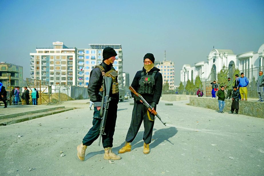 Policemen stand guard at the site of a bomb blast in Kabul on February 2, 2021