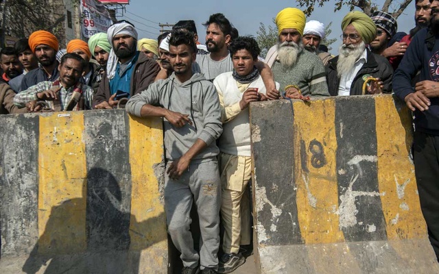 FILE -- Protesters demanding the repeal of new agriculture laws watch in New Delhi on Jan 27, 2021 as the police set up barricades to restrict their movements. Critics say Prime Minister Narendra Modiâ€™s approach to dissent increasingly involves sti