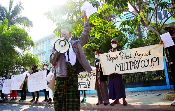 People protest on the street against the military after Monday's coup, outside the Mandalay Medical University in Mandalay, Myanmar.