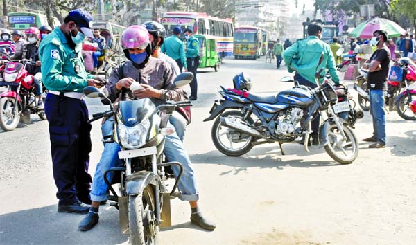 Police checks a motor biker along with his rider for scrutiny of driving license and registration papers to check bike accidents and violence at the Paltan area in the capital on Thursday.