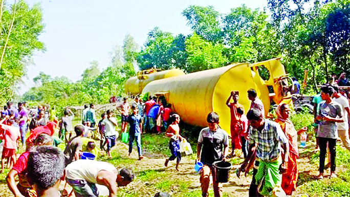 People collect oil spilled from tanker wagons at Maijgaon area of Fenchuganj upazila in Sylhet district on Friday.