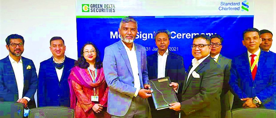 Wafi Shafique Menhaz Khan, MD & CEO of Green Delta Securities Limited (GDSL) and Sabbir Ahmed, MD & Head of Retail Banking of Standard Chartered Bank (SCB) Bangladesh, exchanging an agreement signing document at GDSL head office in the city recently. Unde