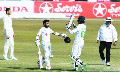 Mohammad Rizwan (left) celebrates with his teammate Nauman Ali (second from right) after scoring a century during the fourth day of the second Test cricket match between Pakistan and South Africa at the Rawalpindi Cricket Stadium in Pakistan on Sunday.