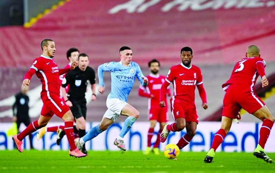 Manchester City's midfielder Phil Foden (center) runs through the Liverpool defence during the English Premier League football match between Liverpool and Manchester City at Anfield in Liverpool, north west England on Sunday.