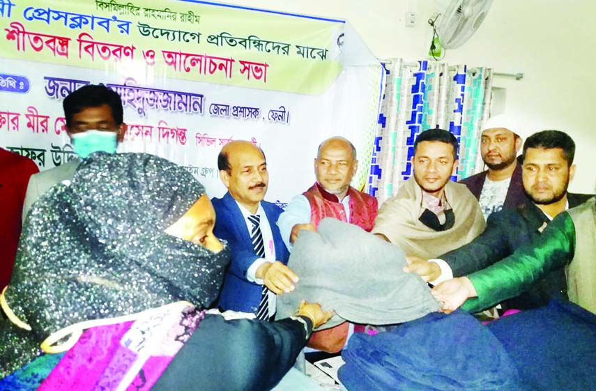 Feni DC Md Wahiduzzaman distributed warm cloths among the distressed people at a ceremony at the Feni Press Club recently.