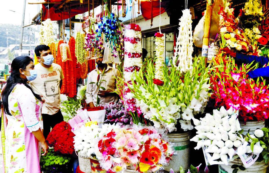 Buyers throng to flower shop amid Falgun and Valentines' Day at Shahbagh area in the capital on Friday.