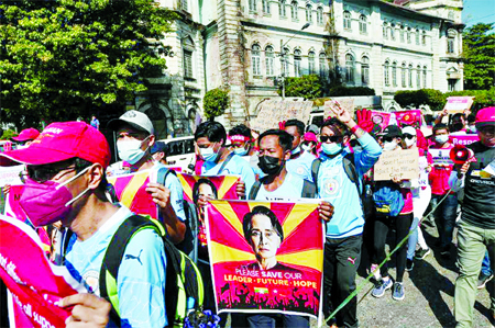 Demonstrators march with signs to protest against the military coup and demand for the release of elected leader Aung San Suu Kyi, in Yangon, Myanmar.