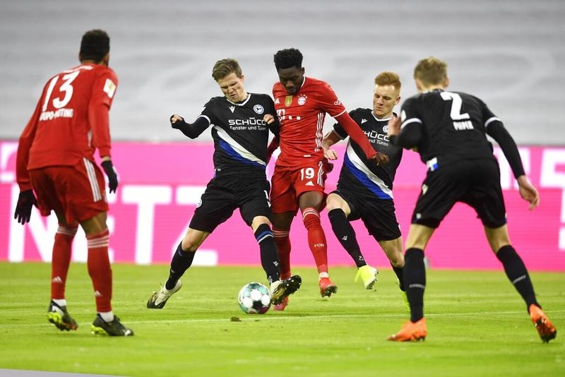 Bayern's Alphonso Davies (center) fights for the ball with Arminia's Christian Gebauer (left) and Fabian Kunze (right) during a German Bundesliga soccer match at the Allianz Arena in Munich, Germany on Monday.