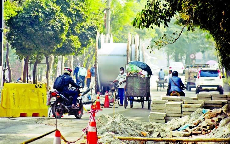Construction materials are being piled up on a road in the capital's Baridhara Diplomatic Zone causing huge inconvenience to the motorists and pedestrians. This photo was taken on Thursday.