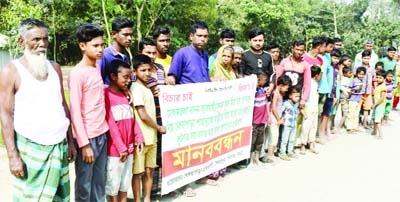 A cross section of people forms a human chain at Syedpur Kharuapara in Shibganj of Bogura district on Friday.