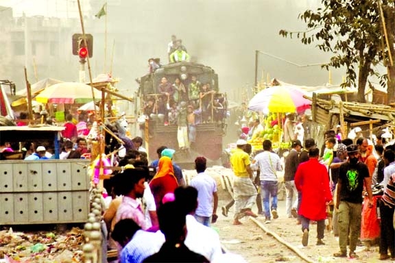 People move risking their lives to two sides of the rail track where illegal establishments have been set up at Jurain area in the capital on Friday.