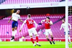 Manchester City's midfielder Raheem Sterling (left) jumps to head home the opening goal of the English Premier League football match at the Emirates Stadium in London on Sunday.