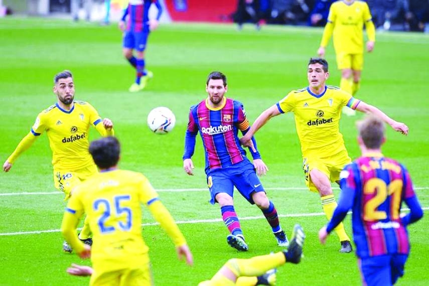 Barcelona's forward Lionel Messi (center) eyes the ball during the Spanish league football match between FC Barcelona and Cadiz CF at the Camp Nou stadium in Barcelona on Sunday.