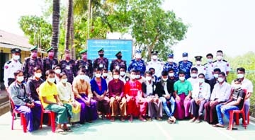 Twenty-four Bangladeshis, who have returned to Bangladesh after serving sentences in Myanmar jails, pose for a photograph with BGB personnel in Cox's Bazar on Tuesday.