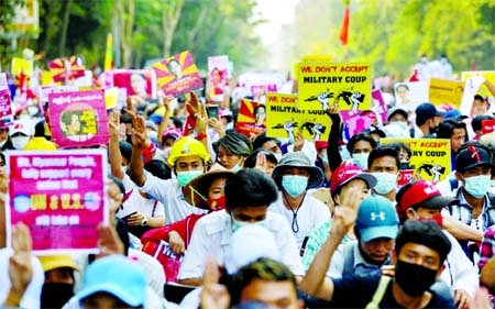 Demonstrators hold placards as they take part in a protest against the military coup in Yangon, Myanmar.