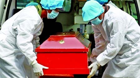 Sri Lankan municipal cemetery workers dressed protective suits carry a coffin of a Covid-19 virus victim for cremation.