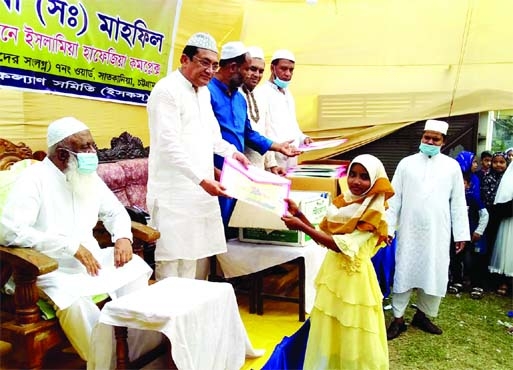 Syed Mahfuz Unnabi, President of Satkania Press Club, distributes prizes among the students at the annual general meeting of Anjumame Islamia Hafezia Complex yesterday.