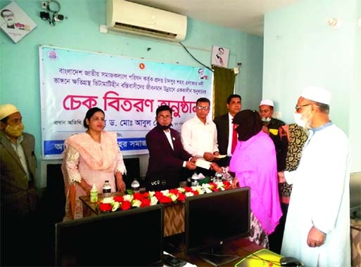 Social Welfare Ministry's Joint Secretary Dr Md Abul Hossain handing over cheques of Tk 4 thousand (Total Tk one lakh) as govt grants to each of a total of 25 poor slum dwellers and river erosion victims in Chandpur Sadar at a function at Samaj