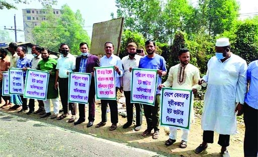 Brickfield owners form a human chain on Chattogram-Cox's Bazar Highway in Lohagara on Tuesday seeking Prime Minister's intervention to keep up their brick manufacturing activities.