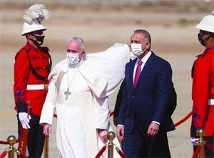 Pope Francis is received by Iraqi PM Mustafa Al-Kadhimi upon disembarking from his plane at Baghdad International Airport to start his historic tour in Baghdad.