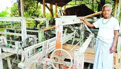 A weaver of ethnic community stands beside his closed weaving factory in Sherpur.