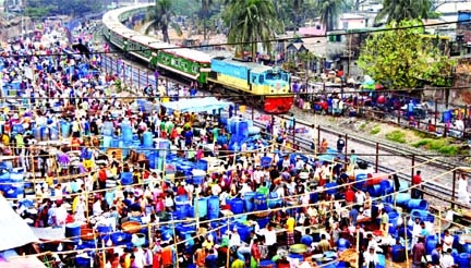 A fish market has been set up across railway track in the capital's Kawran Bazar area violating railway law. This photo taken on Saturday shows that traders sell fish at the market while train is passing through the rail track dangerously.