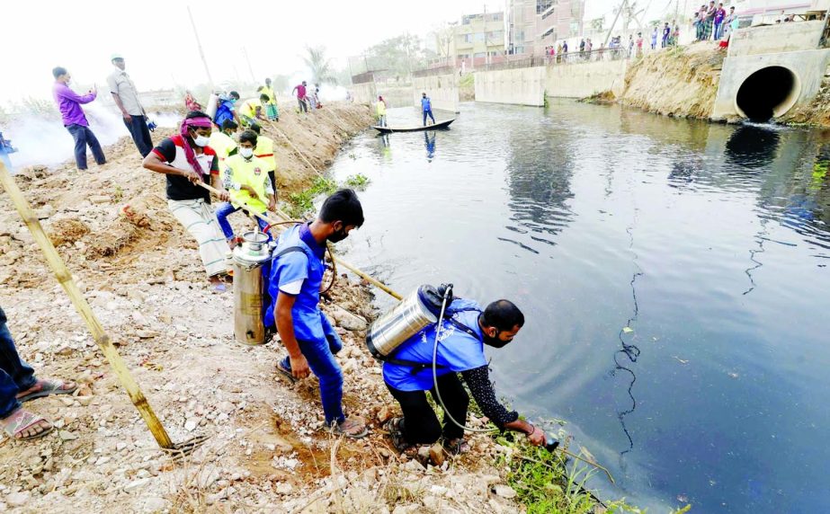 Workers of Dhaka North City Corporation spray insecticide in the capital's Sagufta canal on Monday as part of its mosquito control programme.