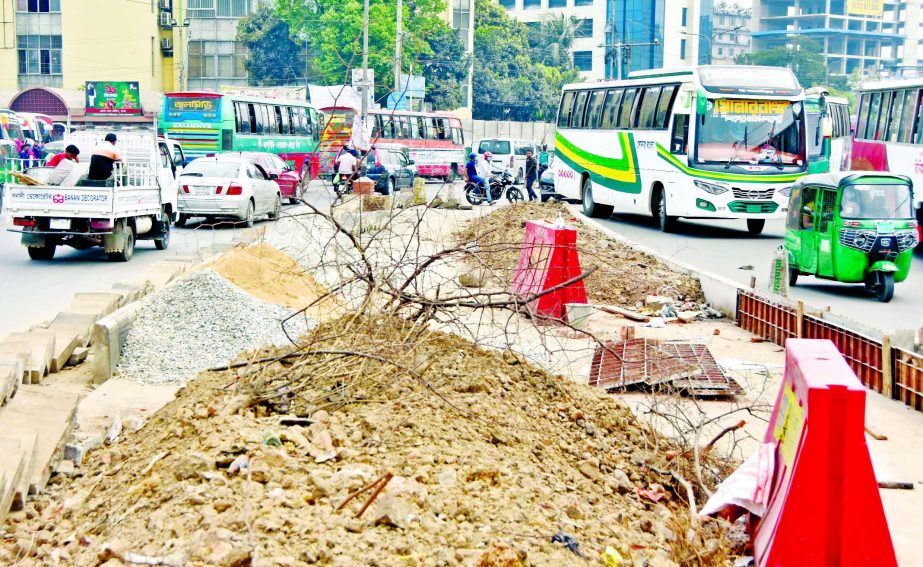 Vehicles ply with difficulty in front of Mohakhali Bus Stand in the capital on Tuesday as roads have been narrowed by construction firms keep materials.