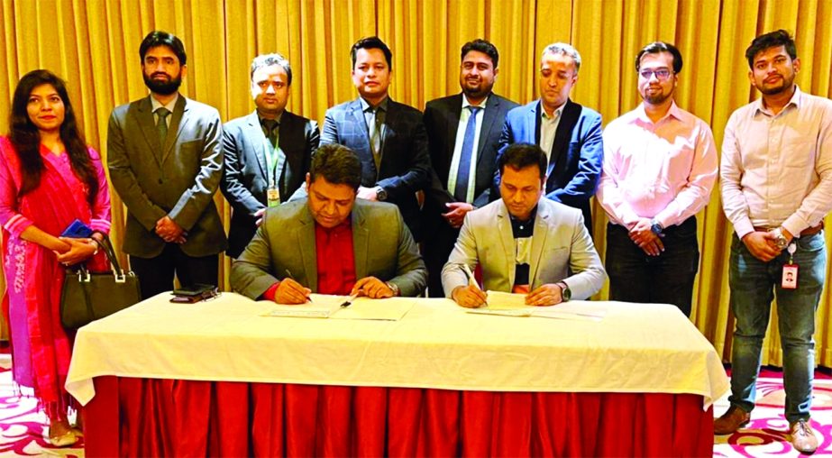 Golam Shahriar Kabir, Executive Director of Minister Group and Sirajul Islam Rana, Chief Operating Officer of Dhamaka Shopping (an online site), signing documents of an agreement at a city hotel on Wednesday. Under the deal, all electronics and human care