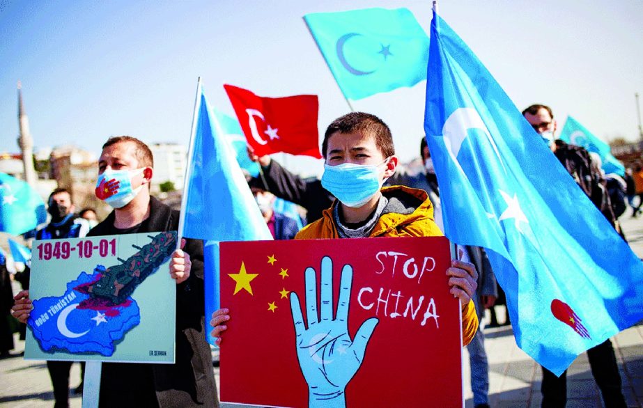 Members of the Muslim Uighur minority hold placards as they demonstrate to ask for news of their relatives and to express their concern, in Istanbul.