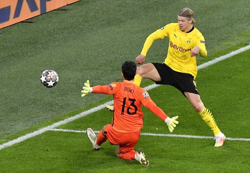 Dortmund's Erling Haaland (right) takes a shot on Sevilla's goalkeeper Yassine Bono during the Champions League, round of 16, second leg soccer match in Dortmund, Germany on Tuesday.