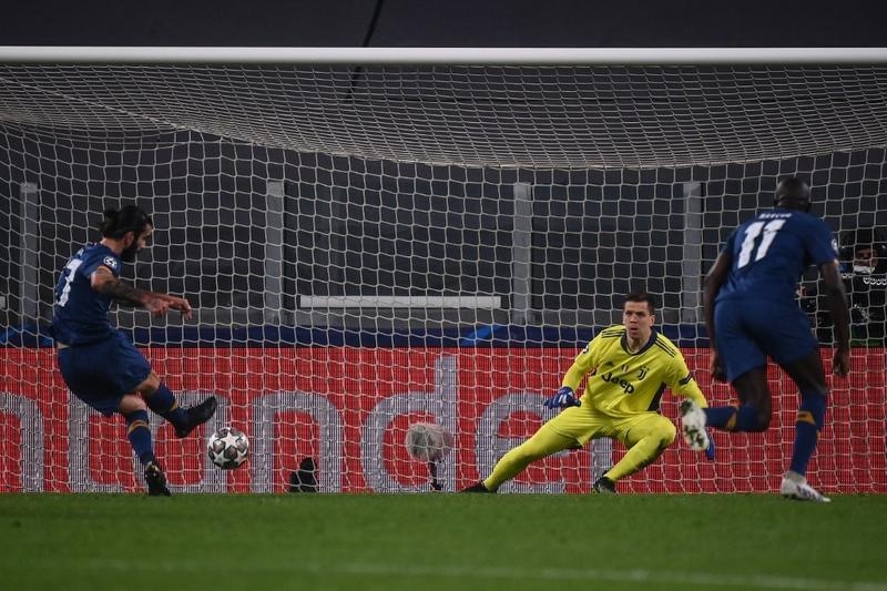FC Porto's midfielder Sergio Oliveira (left) shoots to score a penalty past Juventus' goalkeeper Wojciech Szczesny and open the scoring during the UEFA Champions League round of 16 second leg football match at the Juventus stadium in Turin on Tuesday.