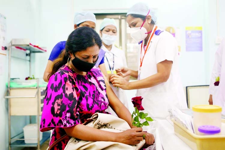 A healthcare worker holding a rose receives the Covid-19 vaccine at a medical centre in Mumbai.