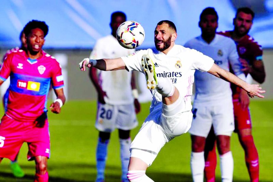 Real Madrid's Karim Benzema (front) jumps for the ball during the Spanish La Liga soccer match against Elche at the Alfredo di Stefano stadium in Madrid, Spain on Saturday.