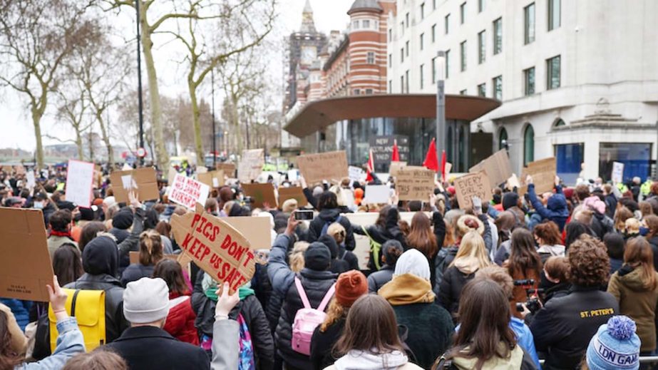 People hold placards during a protest outside New Scotland Yard police headquarters in London.