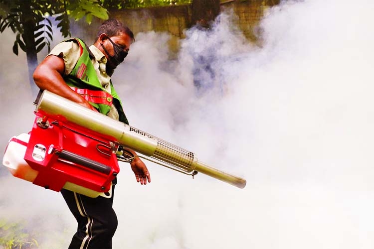 A city corporation worker sprays insecticide from a fogger machine as part of mosquito eradication programme in the city.