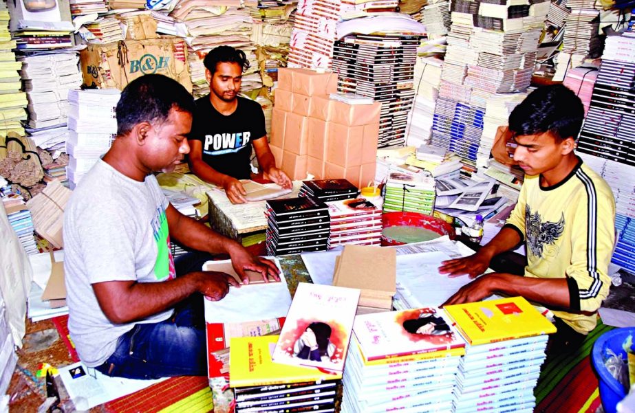 Employees of a publishing house in the capital's Banglabazar area are passing busy time binding books ahead of the month-long Amar Ekushey Book Fair. This photo was taken on Monday.