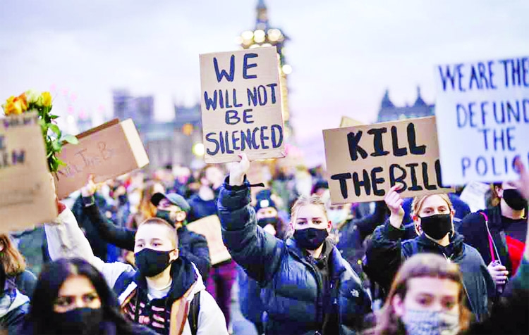 Demonstrators hold signs during a protest, following the kidnap and murder of Sarah Everard, in London, Britain.