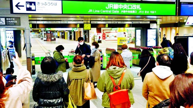 People gather in front of a ticket gate at a station as train services are suspended following an earthquake in Sendai, Miyagi prefecture, Japan.