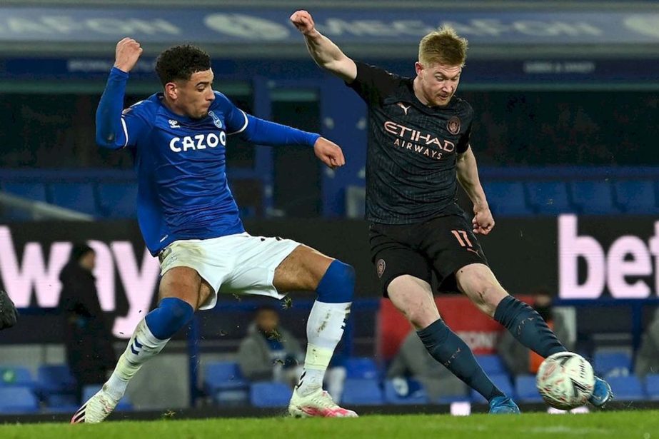 Manchester City's Kevin De Bruyne (right) scores his team's second goal past Everton's Ben Godfrey during the English FA Cup quarter final match at Goodison Park in Liverpool on Saturday.