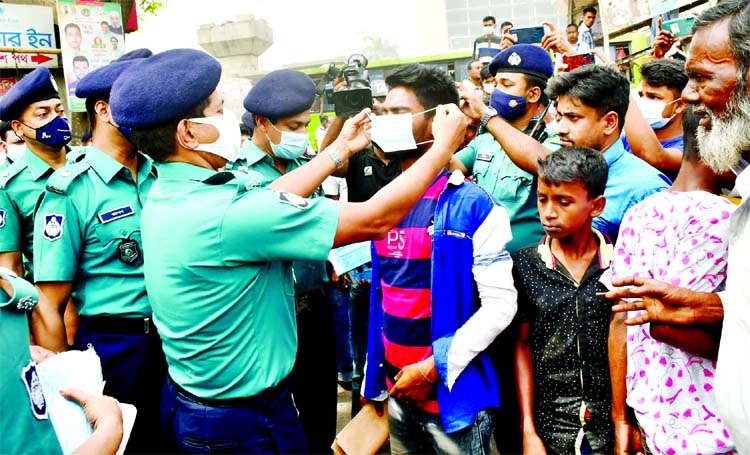Police distributing masks among people during their awareness campaign to control the spread of Covid-19.