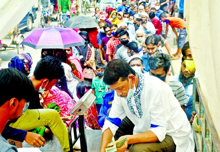 People form a long queue in front of a TCB truck at Shantinagar in the capital to buy essential commodities with total disregard to physical distancing and health norms.